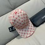 Logo baseball cap with curved brim, red trim, and red button on cream fabric