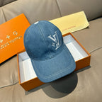 Blue denim baseball cap with large LV logo embroidery on front.