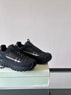 Black lace-up chunky sneakers with check-style side panel on a box