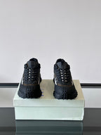 Pair of black lace-up chunky sneakers on the box with deep lug soles
