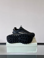 Black lace-up chunky sneakers with rugged tread sole, shown from the side