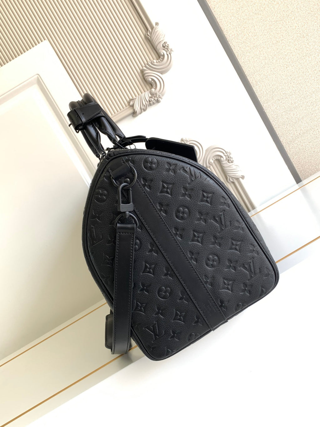 Black monogram duffel bag with adjustable shoulder strap and zip closure