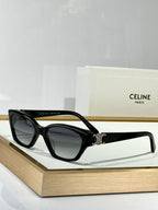 Black cat-eye eyeglasses with dark lenses and gold C emblem on the bridge