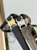 Close-up of black eyeglasses bridge with gold C emblem and metal arms