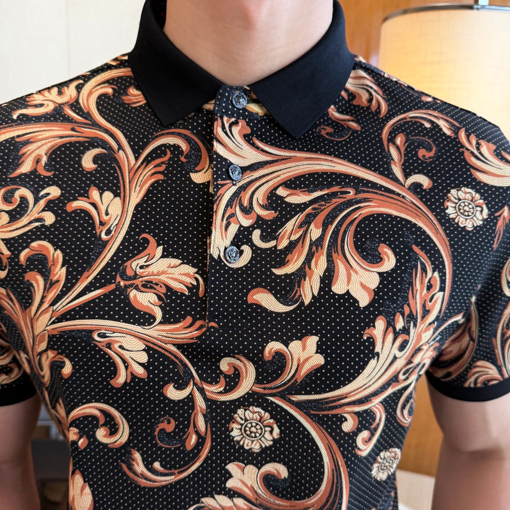 Close-up view of black polo shirt with gold-orange swirling motifs and small dots