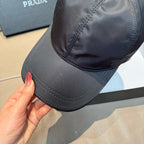 Dark navy PRADA baseball cap, close side view with triangle logo and curved brim