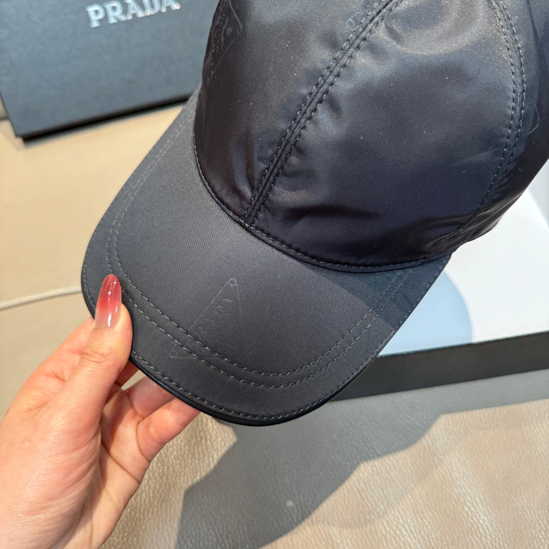 Dark navy PRADA baseball cap, close side view with triangle logo and curved brim