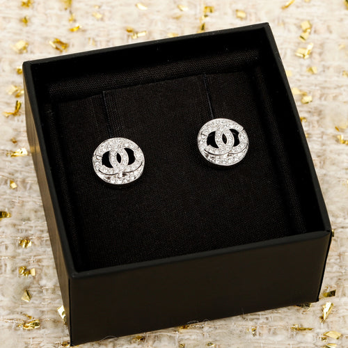 Pair of silver CHANEL logo stud earrings in a black presentation box