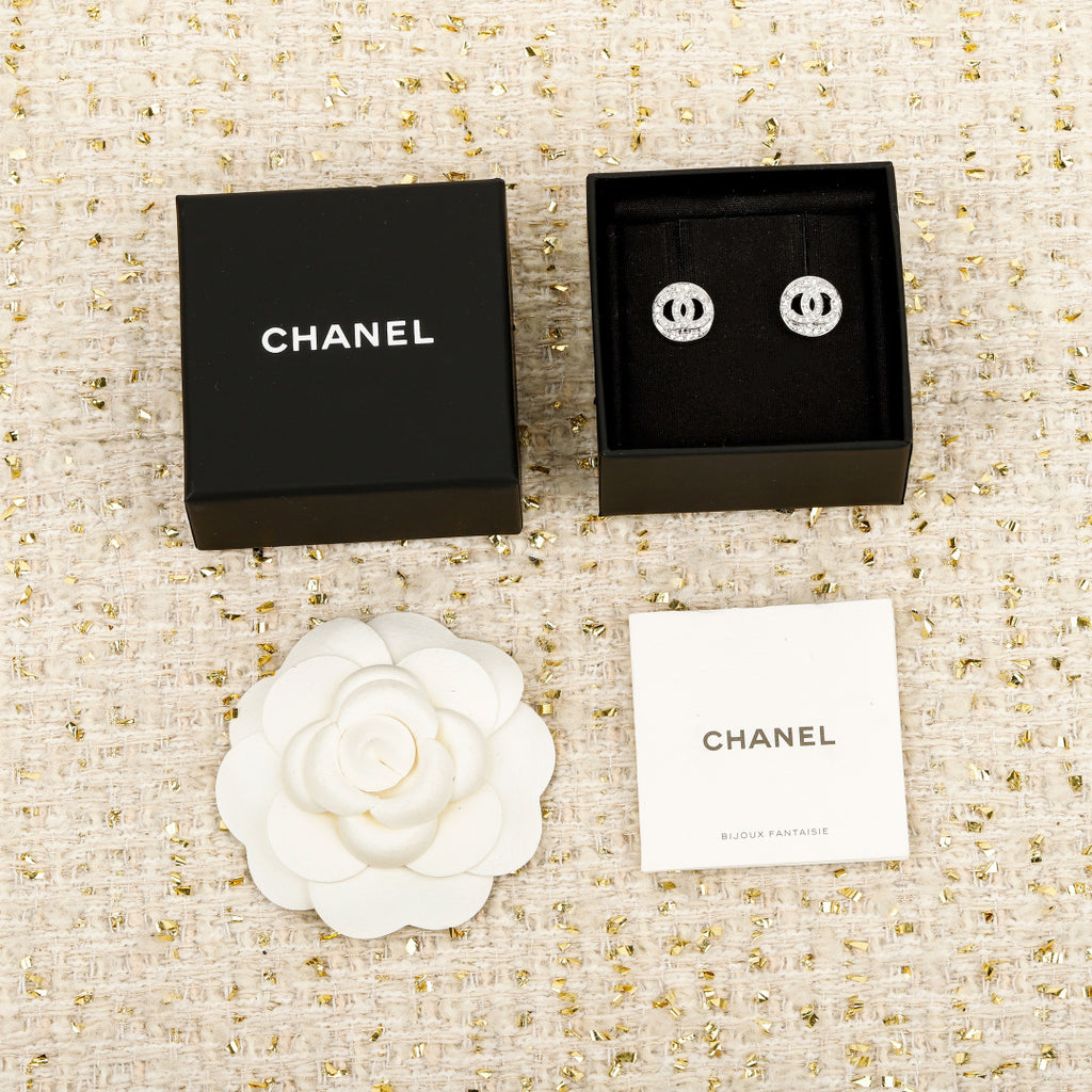 CHANEL stud earrings with black and white gift boxes and a white flower accessory