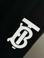 TB logo patch on dark navy track shorts
