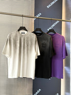 Short-sleeve T-shirts in white, dark gray, and purple with embroidered chest graphics.