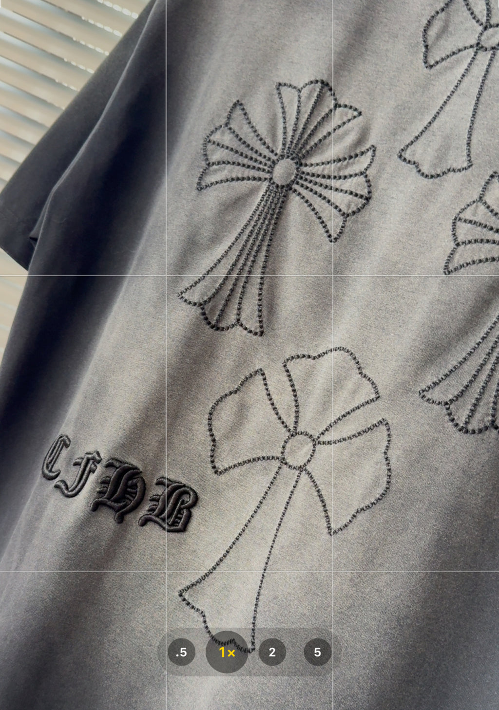 Gray short-sleeve T-shirt fabric with detailed black stitched flower and ribbon embroidery.