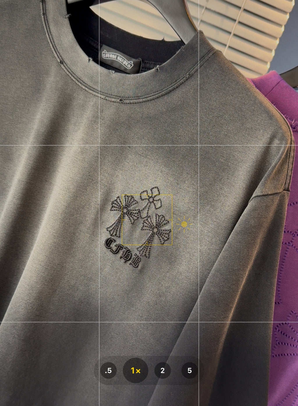 Gray short-sleeve T-shirt with embroidered floral logo on the chest.