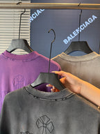 Short-sleeve T-shirts on hangers; gray front shows embroidered flower on the chest.