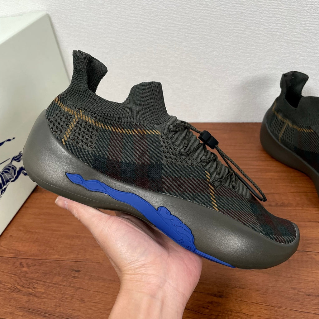 Burberry sneakers close-up, black laces and blue accent stripe on dark knit