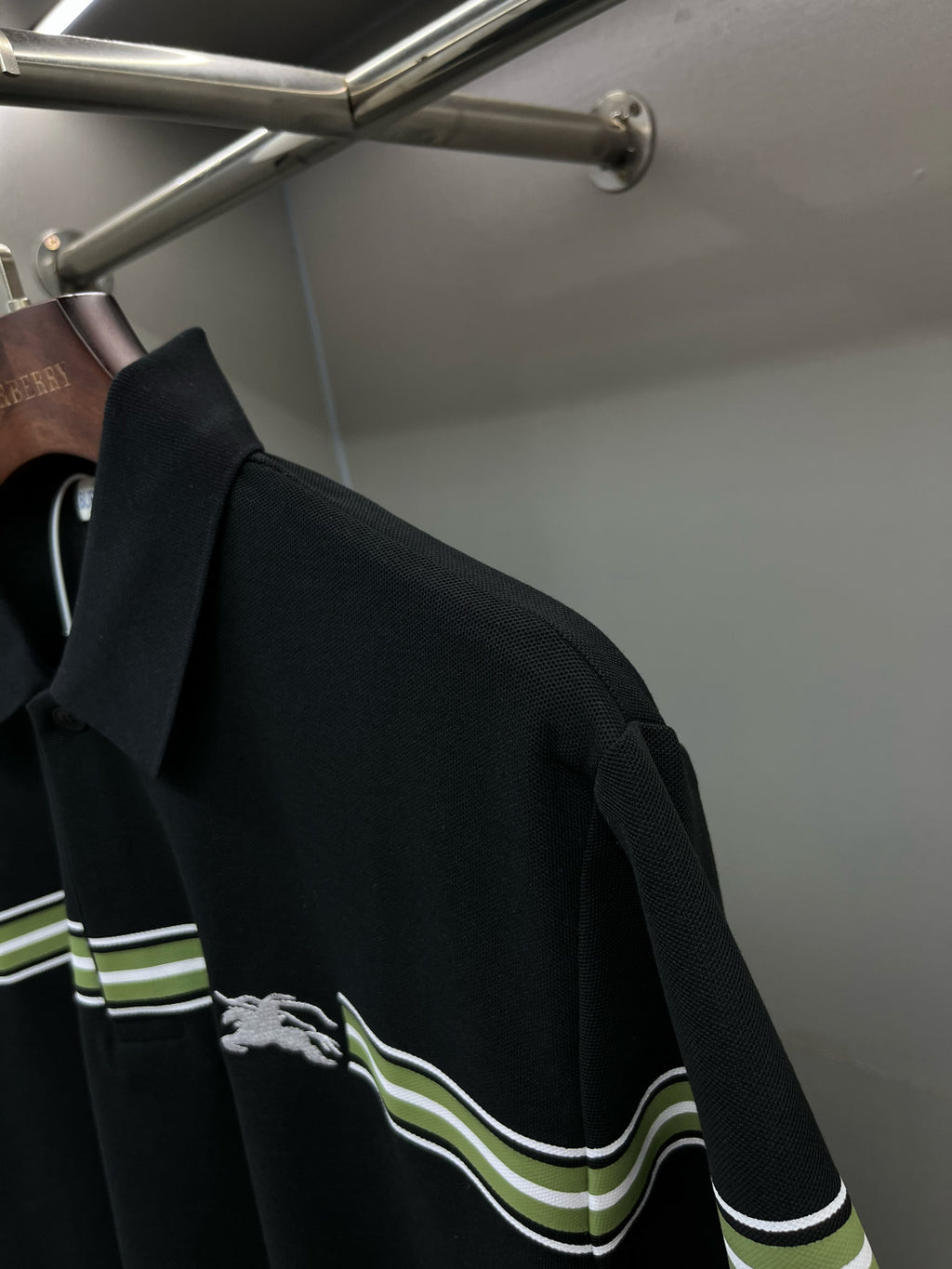 Burberry polo shirt side view: dark navy with green-striped shoulder trim