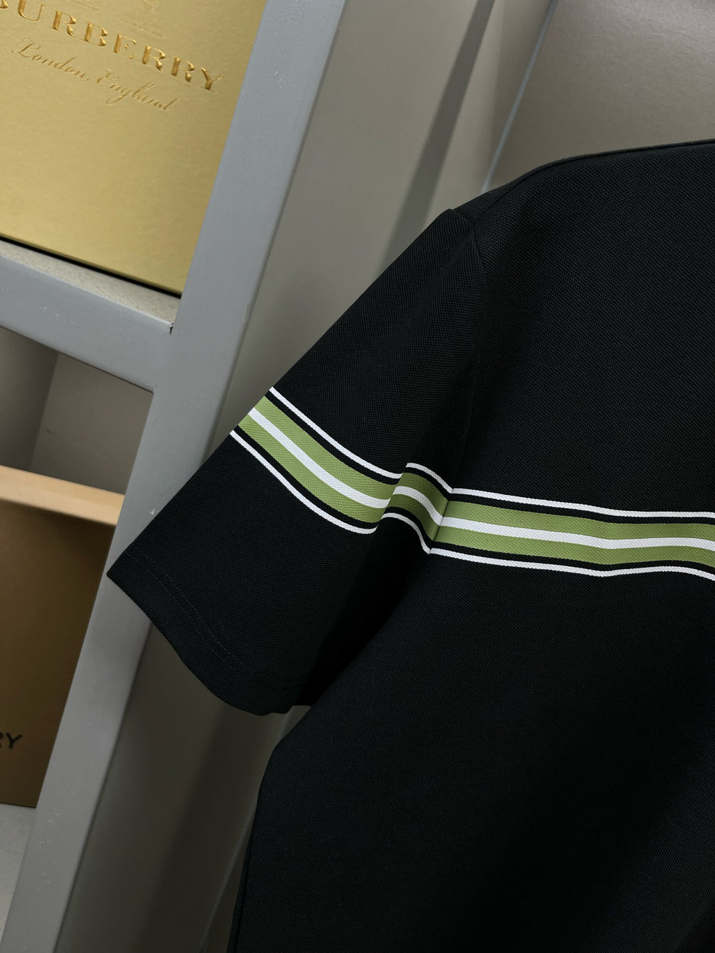 Burberry polo shirt sleeve with green-white stripe band on dark navy cuff