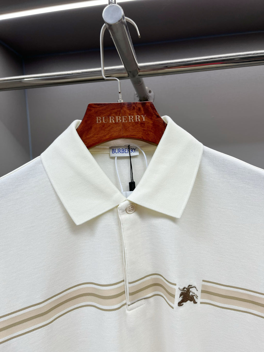 Burberry polo shirt with pointed collar, button placket, and tan-striped horse motif