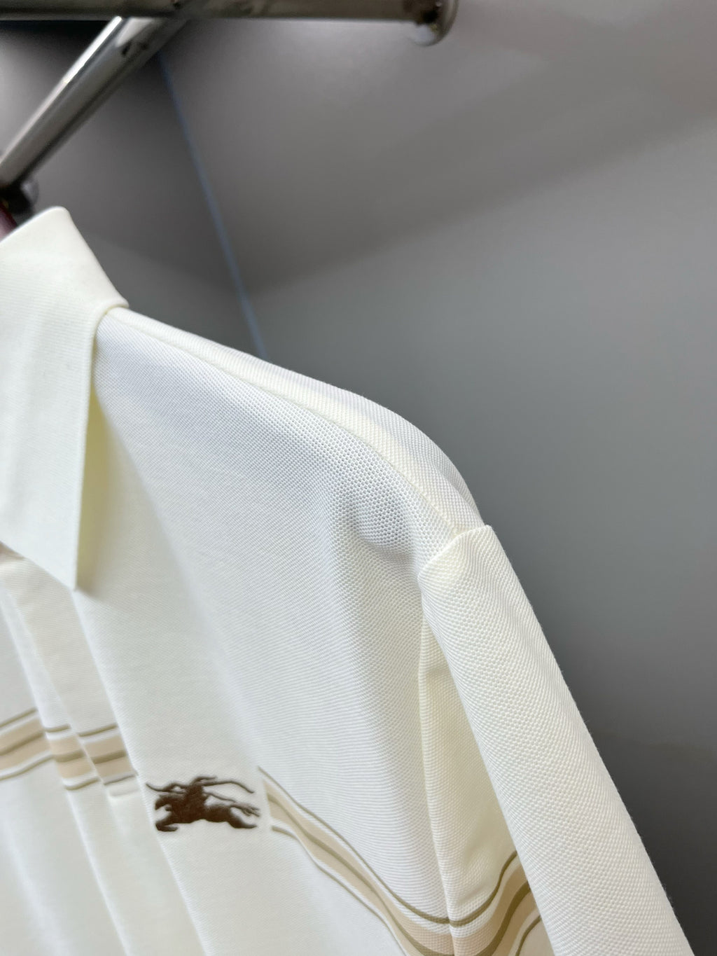Burberry polo shirt sleeve with horse logo and tan stripe band detail