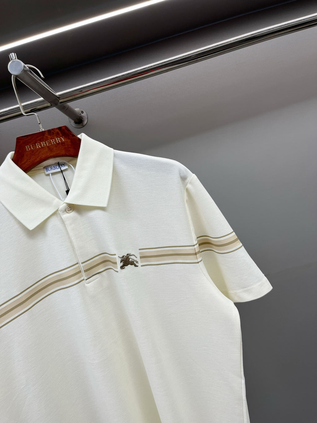 Burberry short-sleeve polo shirt with tan stripe band across chest and horse emblem