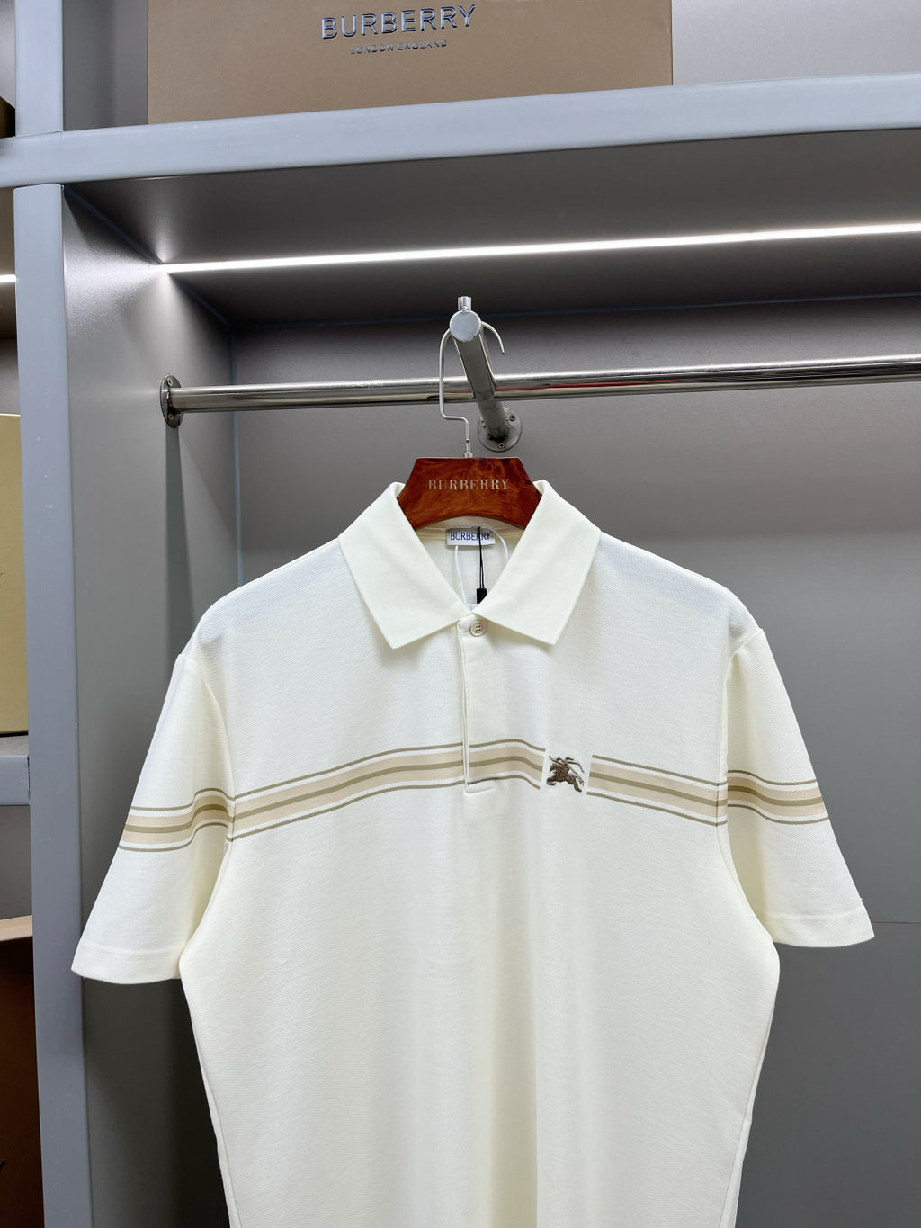 Burberry polo shirt with white collar, button placket, and tan-striped chest detail