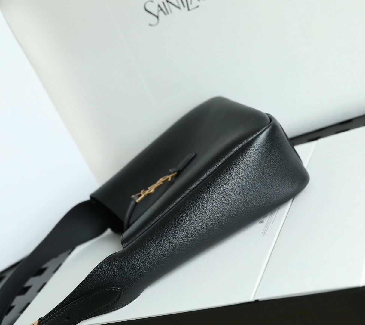 Black YSL belt bag with gold YSL logo detail and curved front flap