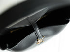 Black YSL bag interior view with stitched edge and gold YSL charm