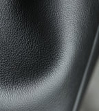 Black pebbled leather panel detail on a YSL bag