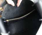 Black YSL bag interior with gold-tone zipper and stitched leather edge
