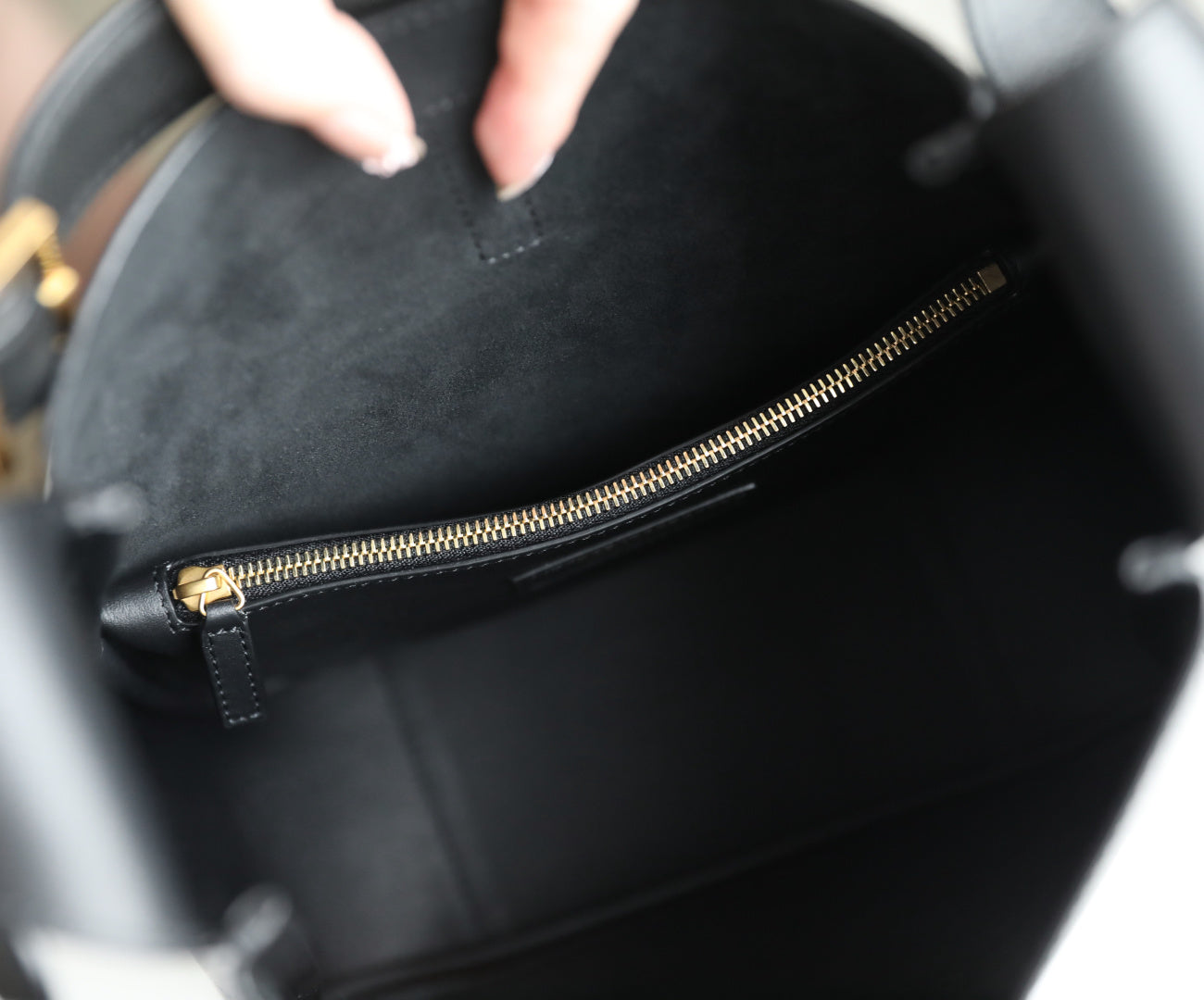 Black YSL bag interior with gold-tone zipper and stitched leather edge