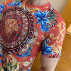 Graphic print T-shirt side view with blue floral pattern and ornate border