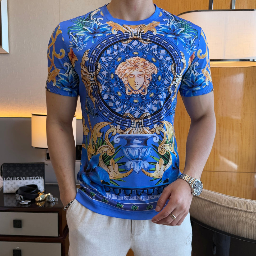 Blue graphic T-shirt with circular Medusa portrait emblem and decorative swirl-and-floral design