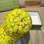 Close view of yellow GG-print cap with round top button.