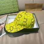 Yellow GG-print baseball cap with top button and curved brim.