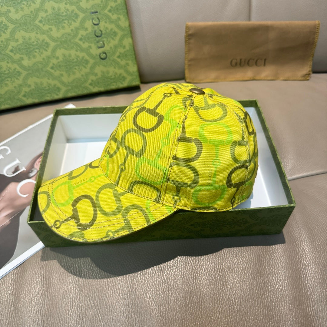 Yellow GG-print baseball cap with top button and curved brim.