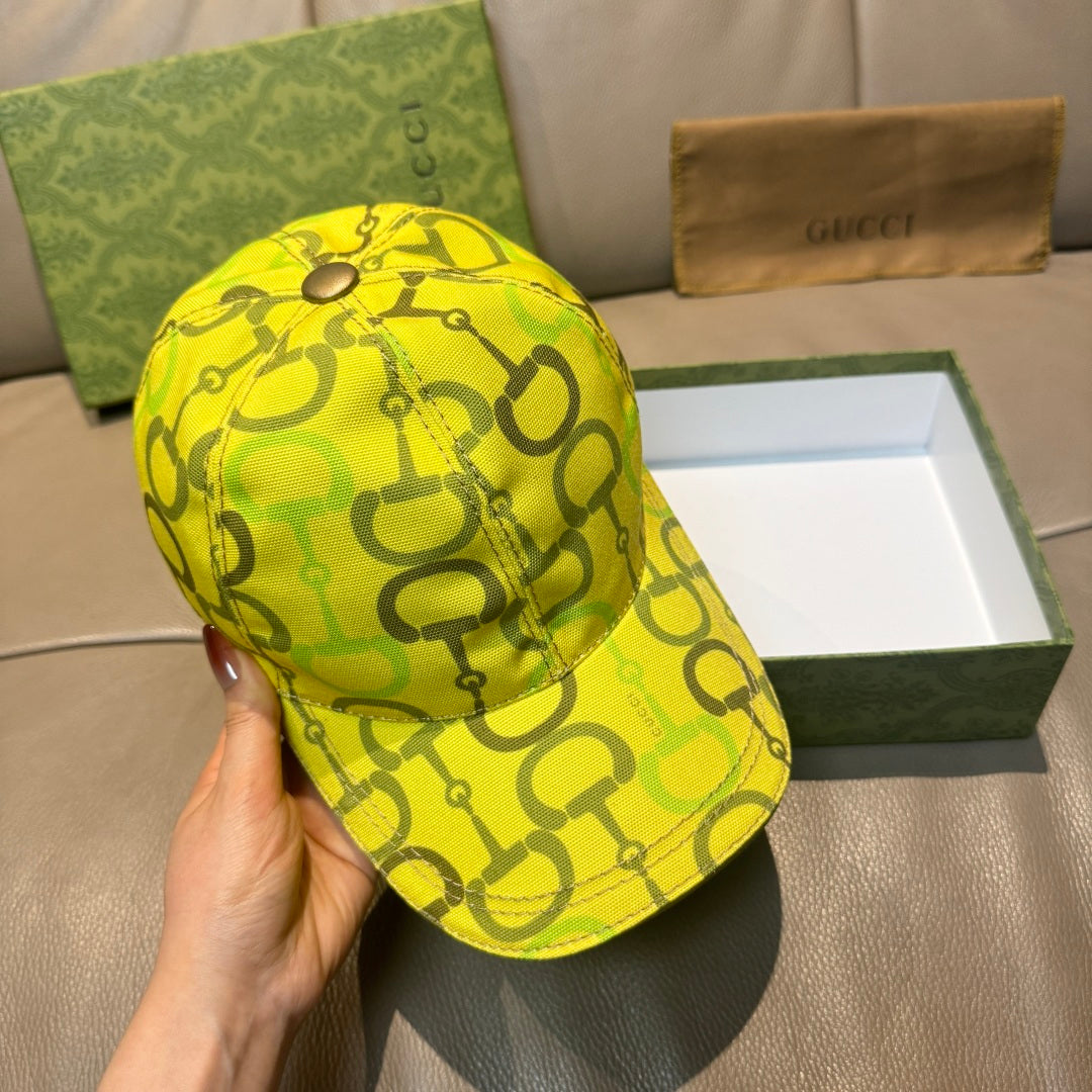 Yellow GG-print baseball cap with metal top button and curved brim.