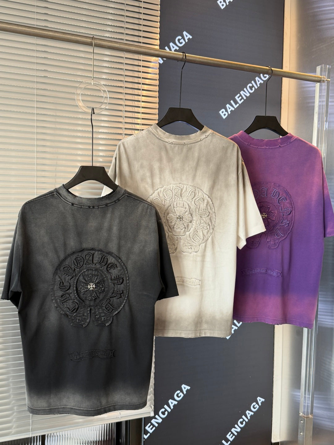 Crewneck short-sleeve T-shirts in black, cream, and purple with circular crest prints