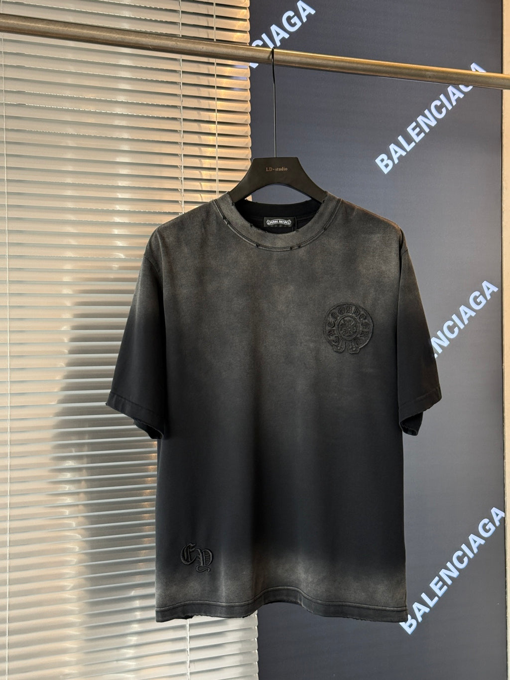 Dark gray crewneck short-sleeve T-shirt with small front crest graphic detail