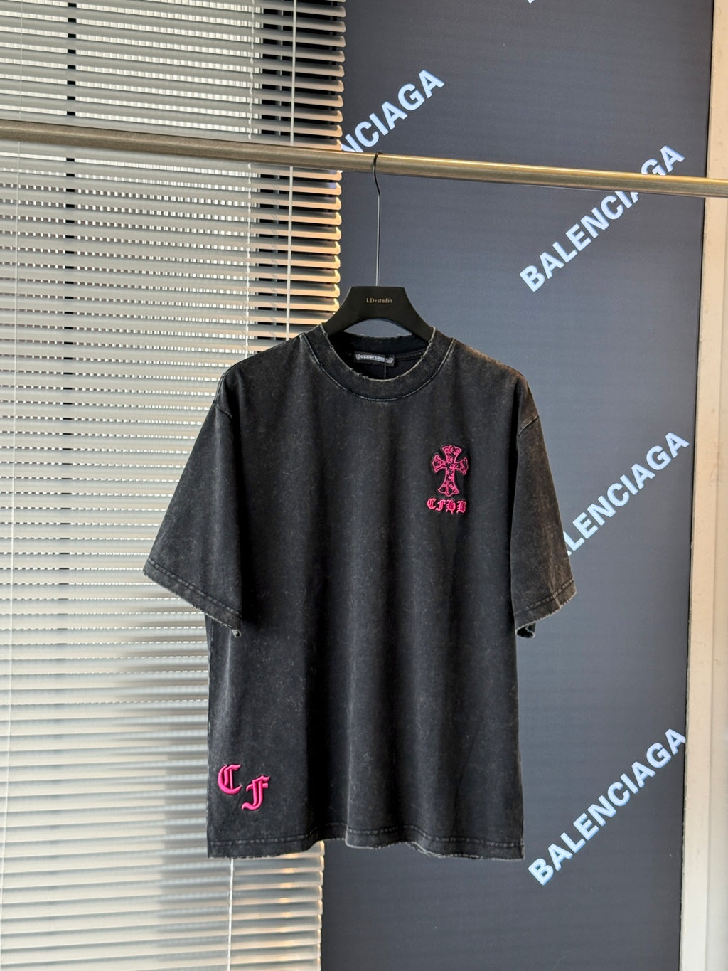 Black short-sleeve T-shirt with pink embroidered crest logo on the chest