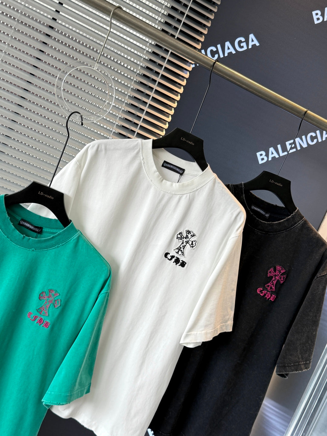 White, black, and turquoise short-sleeve T-shirts with embroidered crest logos on chest