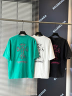 Turquoise, white, and black short-sleeve T-shirts with colorful embroidered crest graphics