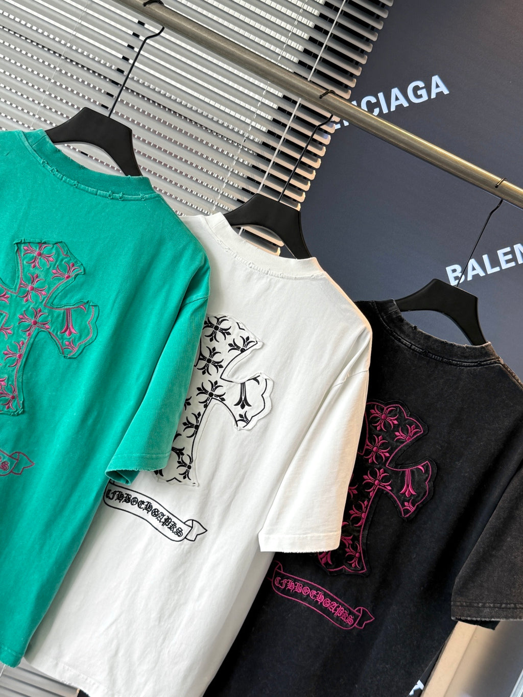 White, turquoise, and black short-sleeve T-shirts with colorful embroidered crest details