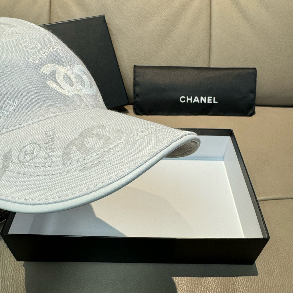 Chanel cap light white showing curved brim edge and CC logo fabric