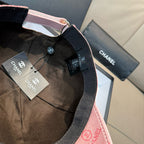Black baseball cap with adjustable strap and Chanel tags, with pink trim