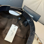 Dark Chanel cap with CHANEL label and adjustable strap, hanging tag