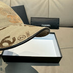 Beige Chanel cap brim detail with black trim on a presentation box