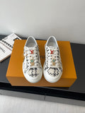 Louis Vuitton women's sneakers in white with black patterned panels, lace-up.