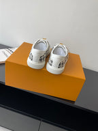 Louis Vuitton women's sneakers, white back view with black patterned uppers and white soles.