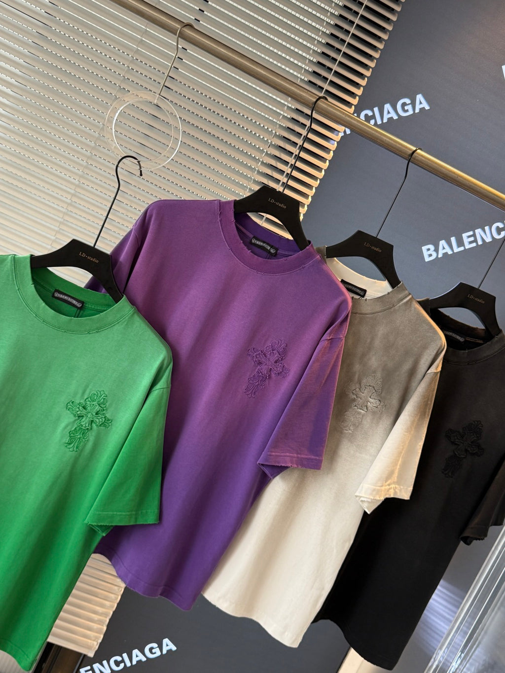 Short-sleeve T-shirts in green, purple, off-white, and black with chest graphic