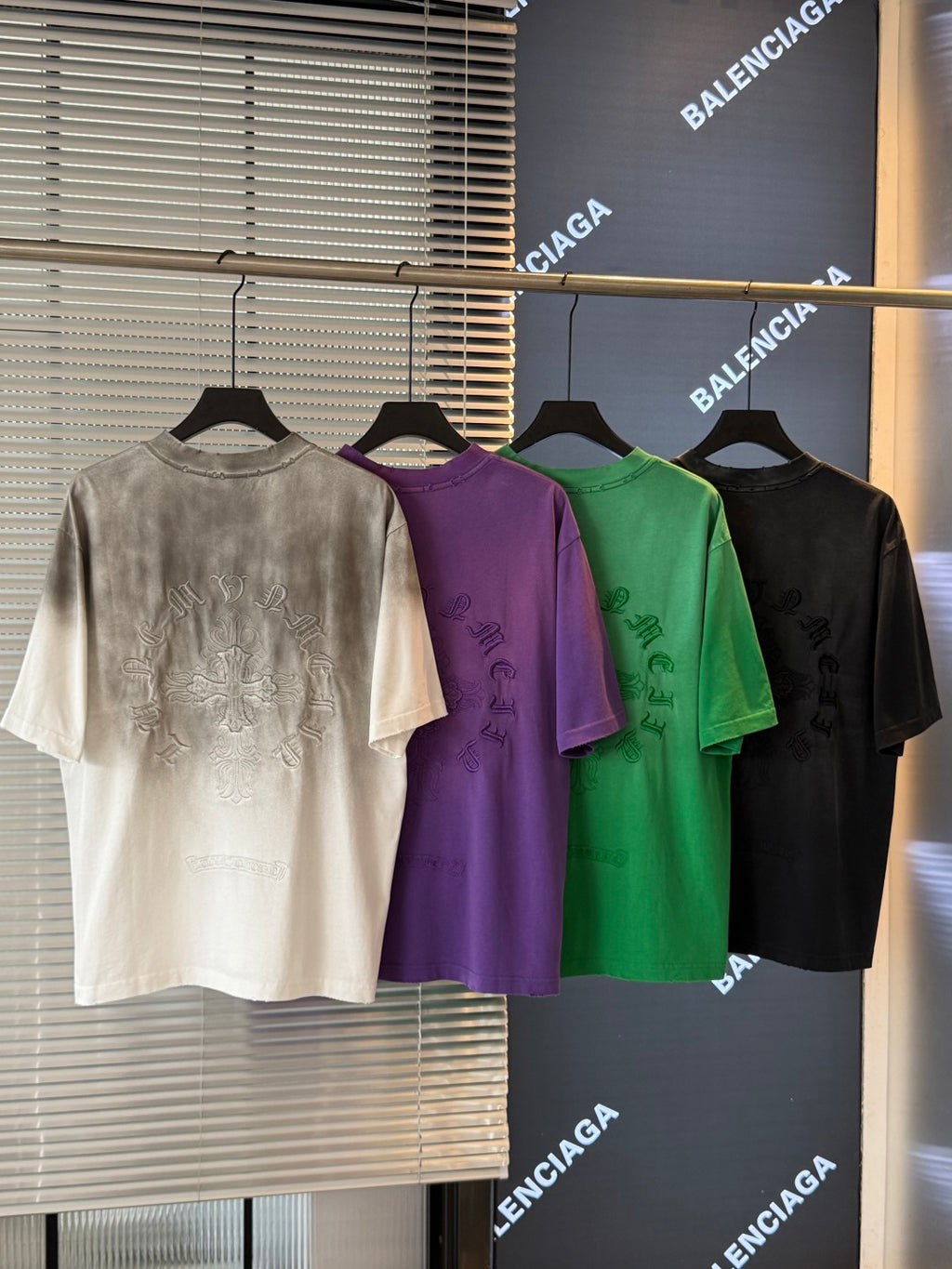Short-sleeve T-shirts in off-white, purple, green, and black with small chest graphic